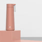 Dusty pink stainless steel portable thermos cup with carry loop and flip-top lid