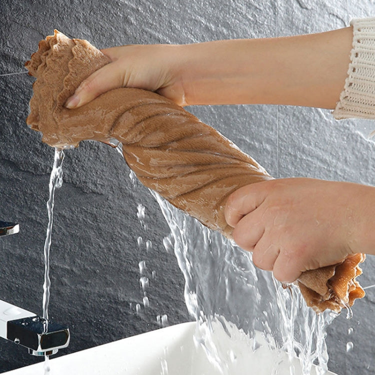 Brown coral fleece bath towel being wrung, showing water dripping from fabric