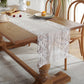 White lace table runner draped on dining table, scalloped lace borders and striped center