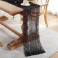 Black lace table runner centered on dining table, floral lace trim and vertical stripes