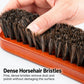 Close-up: hands pressing dense bristles of a wooden shoe dust brush on the base
