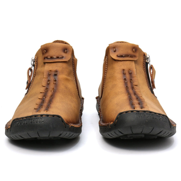 Pair of men's tan leather ankle boots with lace-up tabs and black outsole tread