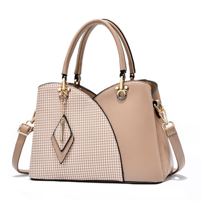 Two-tone lattice texture handbag with check panel, tan sides, top handles, and dangling charm