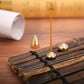 Gold incense insert plate with burning incense stick inserted through top