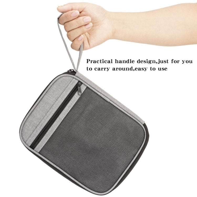 Gray portable mesh storage bag with zipper and carry handle, shown being held open.