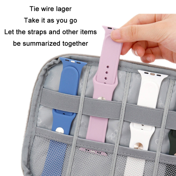 Open gray storage bag with organizer compartments holding smartwatch straps and accessories