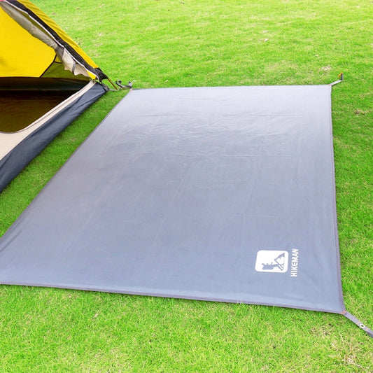 Grey waterproof tent ground mat with corner stakes on grass