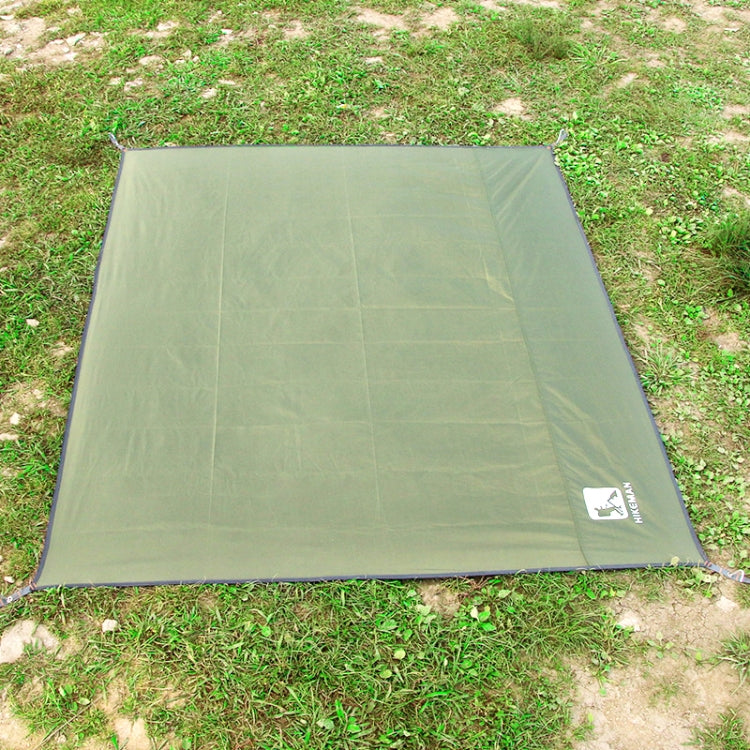 Green waterproof outdoor mat with logo patch and corner stakes on grass
