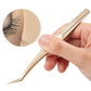 Gold eyelash tweezers held by hand, showing long etched handle and pointed end