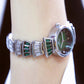 Ladies wrist watch on wrist with green dial, silver-tone case, and green stone accents