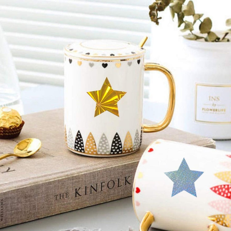Gold star sealing sticker on a white mug with decorative gold accents