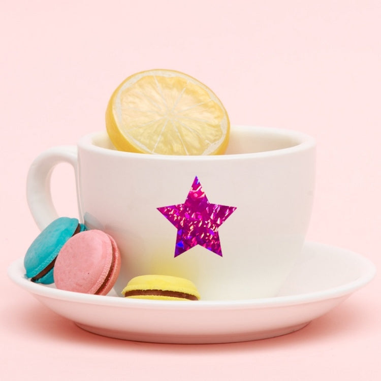 Purple glitter star sealing sticker on a white cup and saucer with treats