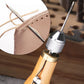 Leather stitching tool with metal needle, shown sewing a light leather piece