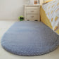 Light blue-gray oval plush pet bed pad with soft shag pile and flat surface