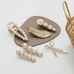 Assorted pearl and rhinestone hair clips with gold-tone bow and leaf designs
