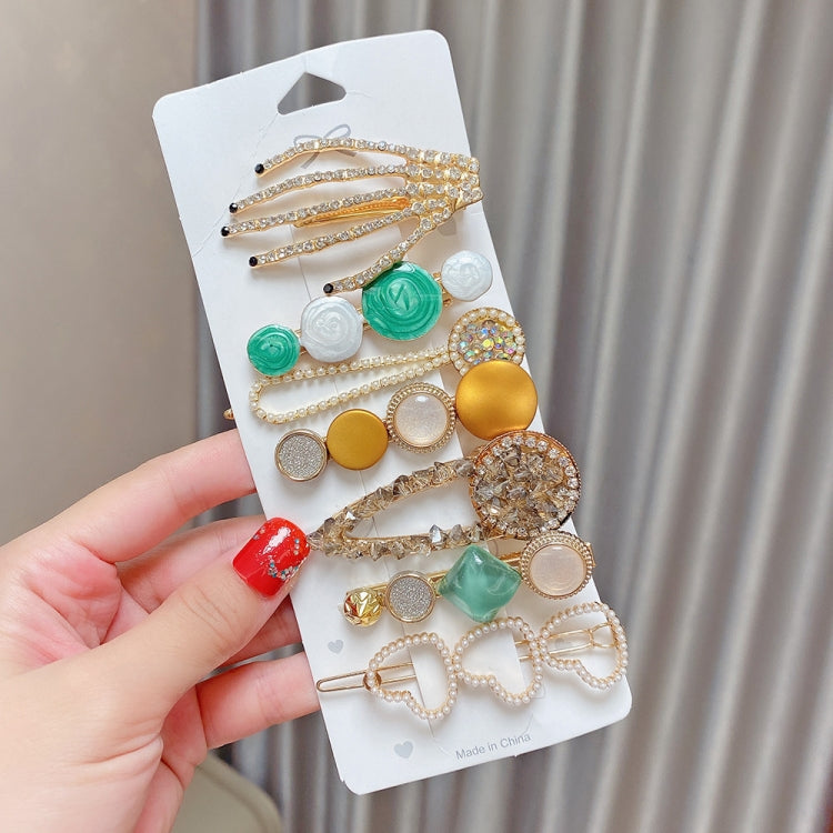 Assorted hair clip set with gold beaded strands, pearls, and green resin accents