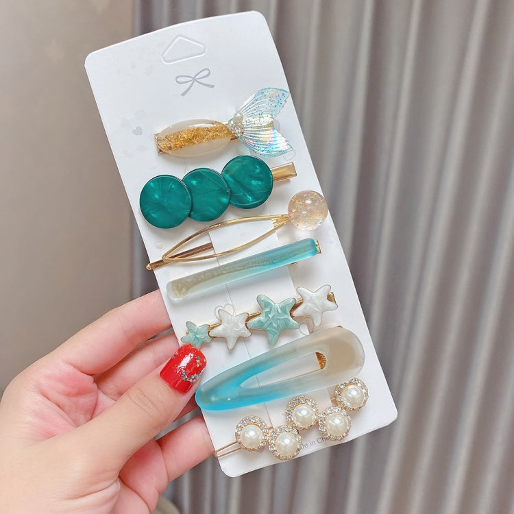 Sea-green hair clip set with pearl bow, green discs, star charms, and blue pin