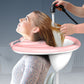 Hair-washing in a pink reclining shampoo basin with shower hose connection at head level