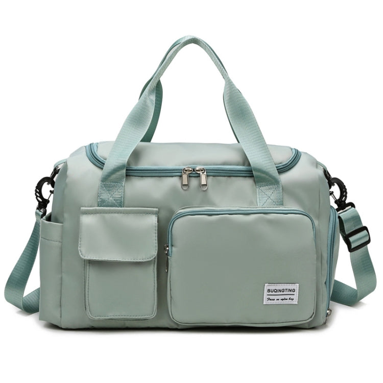 Seafoam green waterproof travel gym bag with front zip pocket, dual handles, and shoulder strap