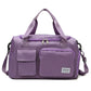 Purple waterproof travel duffel bag with front pockets, zip top, and shoulder strap