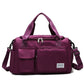 Dark purple waterproof travel duffel bag with front pockets, zip top, and shoulder strap