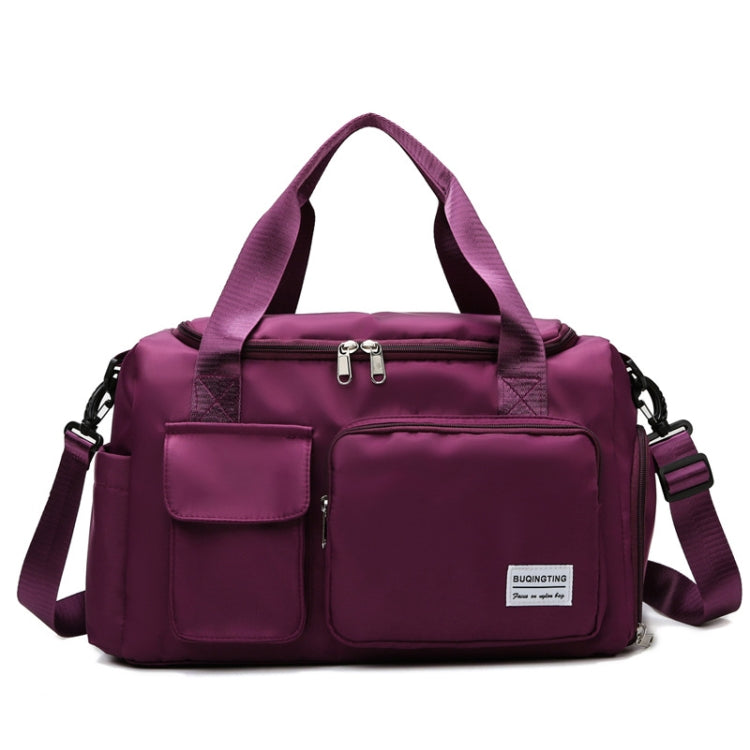 Dark purple waterproof travel duffel bag with front pockets, zip top, and shoulder strap