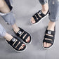 Men's black slide sandals with white-striped cross straps, open toe