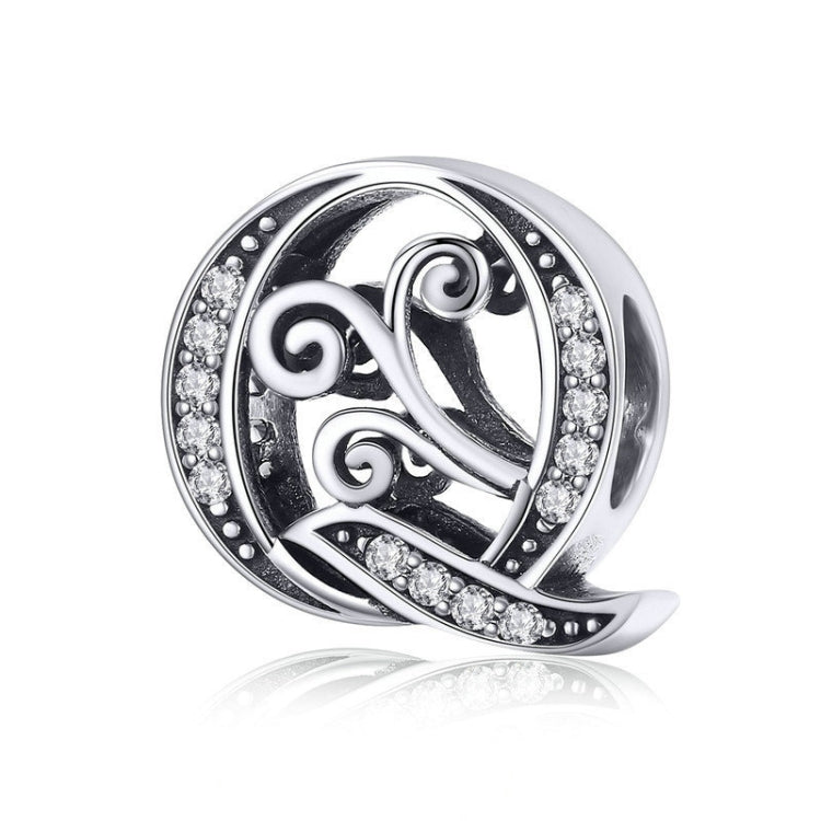 Silver-tone circular ring charm with black enamel scrollwork and rhinestone border, “Q”