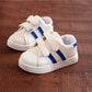 Children's white sneakers with blue side stripes and double hook-and-loop straps, pair