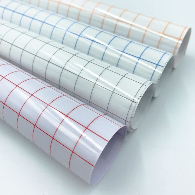 Rolled clear transfer film with grid lines in orange, blue, and red on white backing