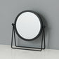 Desktop makeup mirror with round glass and black frame, on a folding black A-frame stand