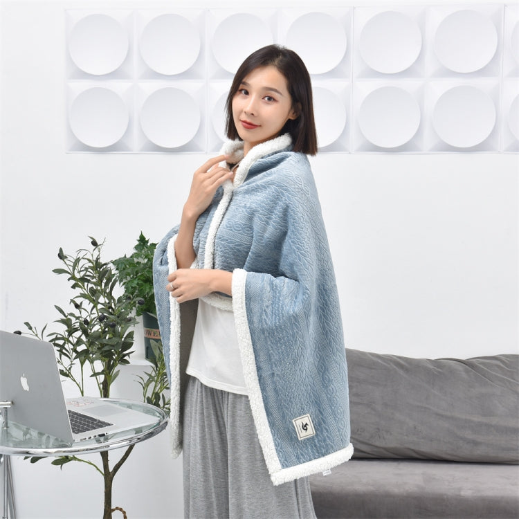 Flannel shawl blanket in misty blue with white fleece trim, worn like a cape