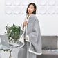 Flannel shawl blanket in light grey with white fleece trim, worn like a cape