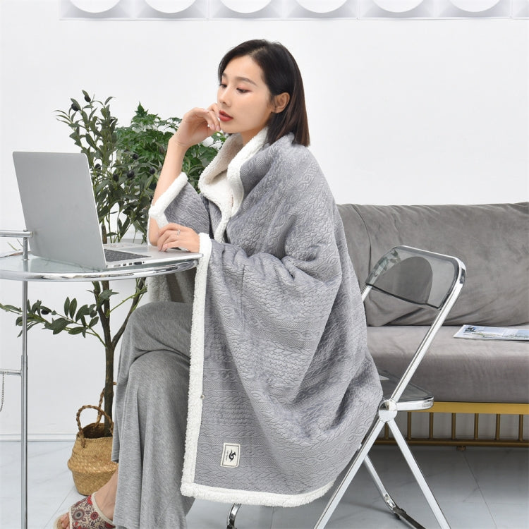 Light grey flannel shawl blanket with white fleece trim, draped for indoor use