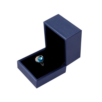 Dark blue PU leather ring jewelry box with open lid and silver ring with blue stone