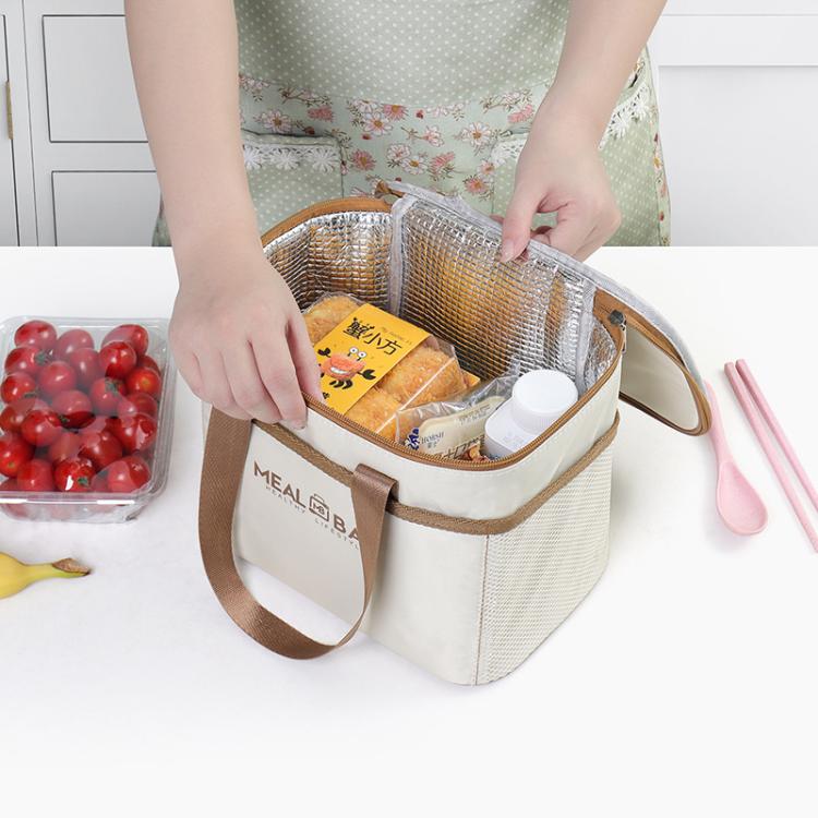 Cream insulated lunch bag with brown handles, open top holding food containers