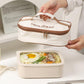 Cream insulated lunch bag with brown zipper, hands holding the open top compartment