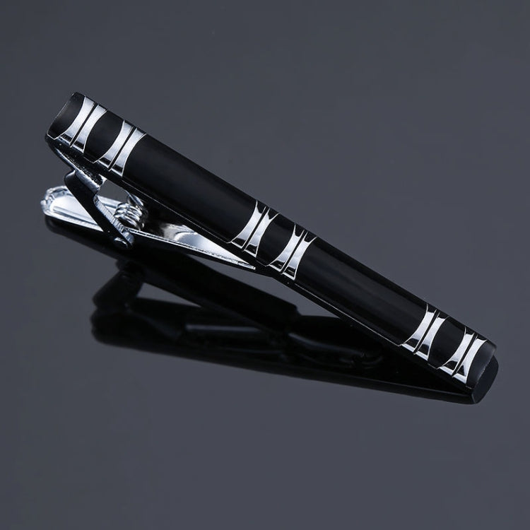 Black and silver striped tie clip with engraved line accents and hinged clasp.