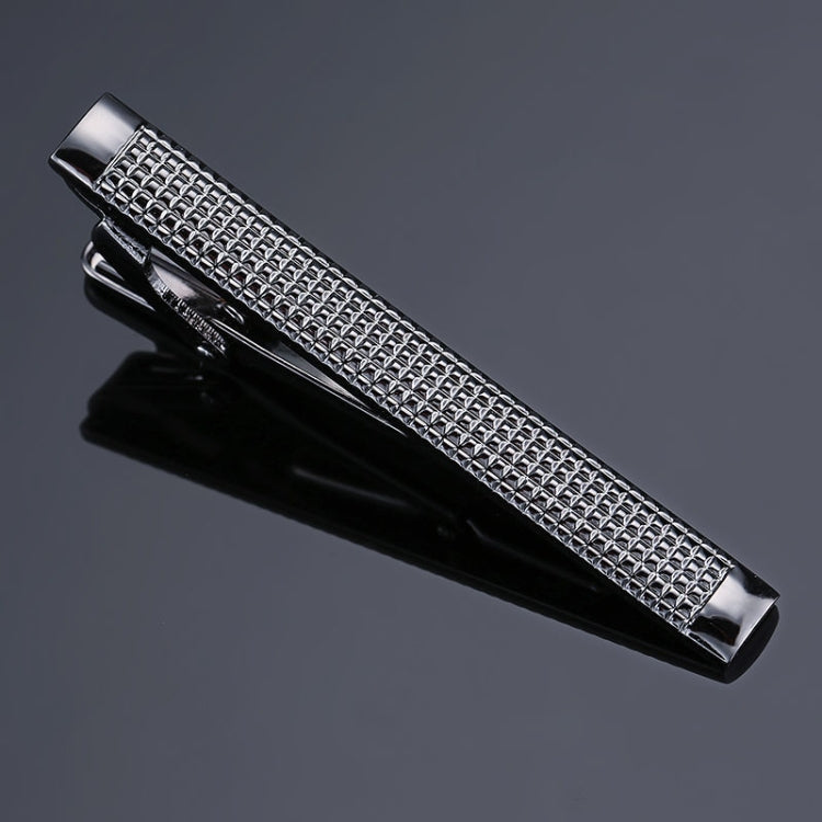 Silver tie clip with diamond mesh pattern over glossy black metal base