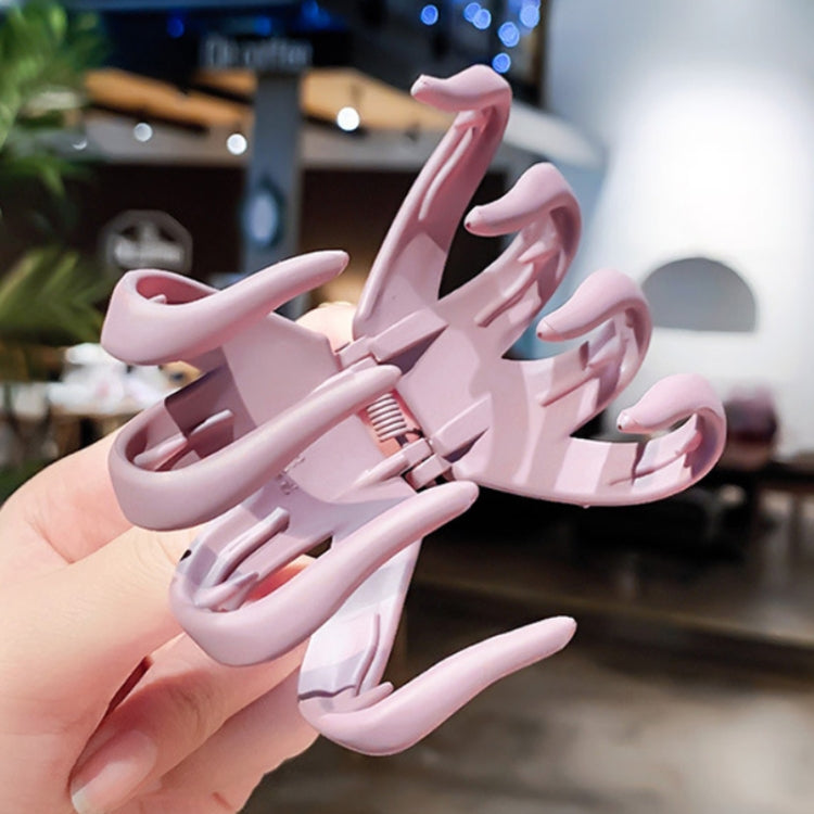 Pink frosted hair grab claw clip held in a hand
