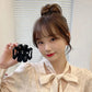 Black frosted claw hair clip set; model holds one clip by a bun