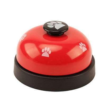 Red dog training bell with black paw-print button and round base.