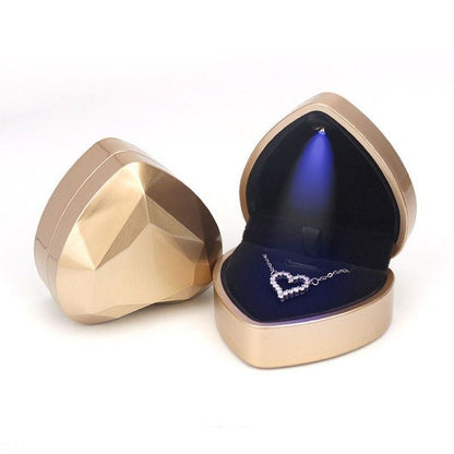 Heart-shaped LED jewelry storage box, gold with open lid and ring on velvet cushion