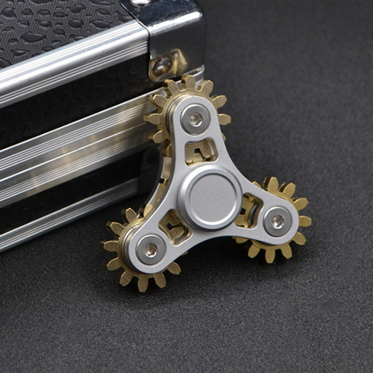Silver linkage fidget spinner toy with gold gears and large circular center piece