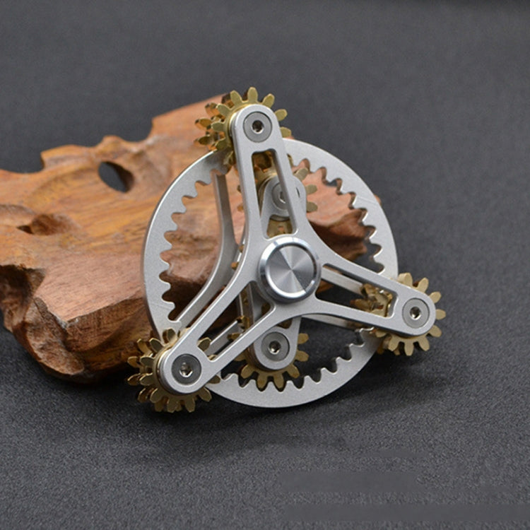 Silver linkage fidget spinner toy with four gold gears and gray gear frame