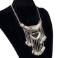 Tassel statement necklace with silver chain, ornate crescent bib, and dark center stone