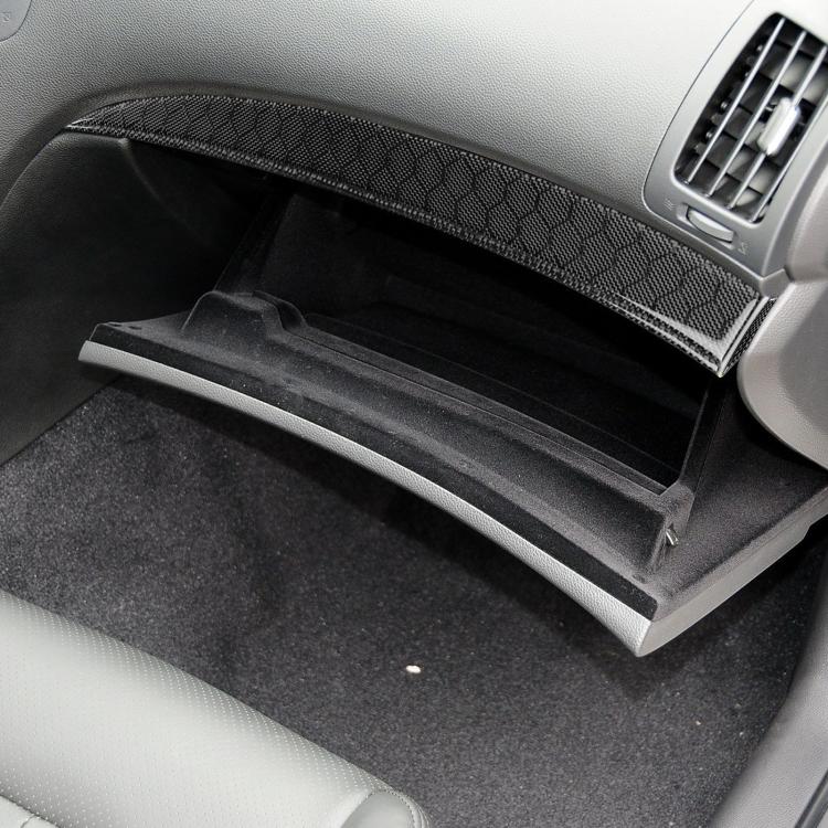 Carbon-fiber style air outlet trim sticker along lower dashboard near passenger-side vent