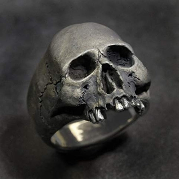 Silver-tone skull ring close-up with hollow eyes and metallic teeth