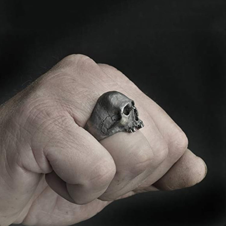 Skull ring on hand, small silver-tone skull face with cracked texture