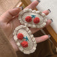 Pair of cream knit oval hair clips with red cherry and blue stem accents